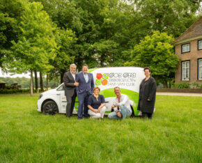 Vijf mensen poseren bij een bestelbus met het logo ‘Goei Gerei Streekproducten Land van Cuijk’, naast een boerderij en groene bomen.